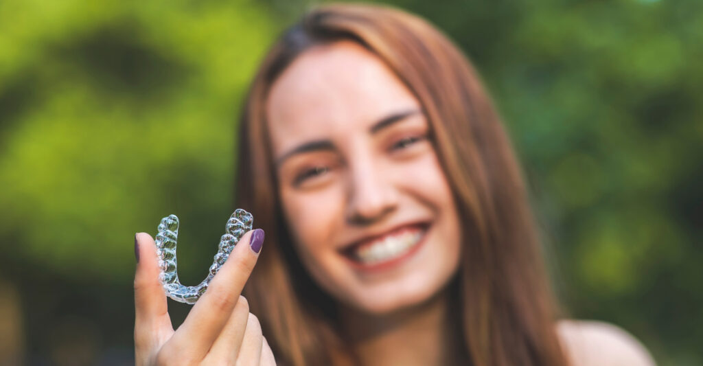 woman is holding an invisalign