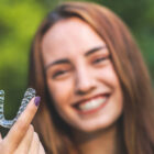 woman is holding an invisalign